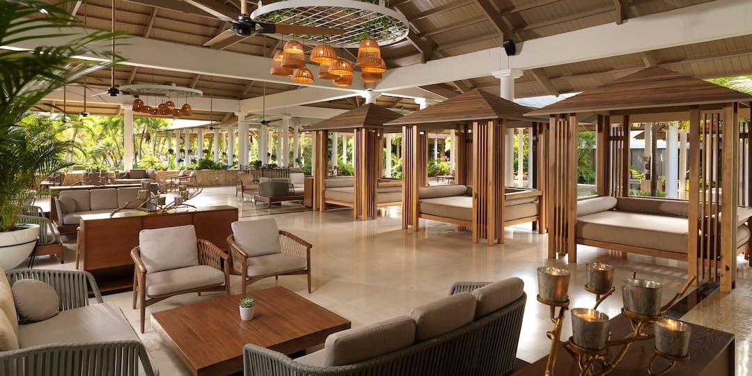 Lobby abierto con salas y camas de madera
