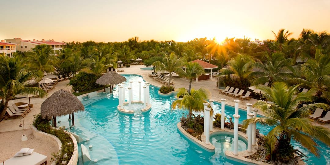 Piscina con columnas y palmeras al amanecer